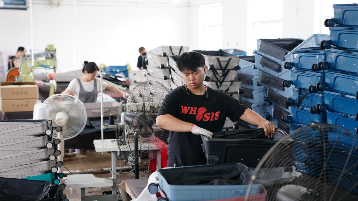 7月4日，工人在白溝新城鵬杰皮具有限公司生產(chǎn)車間忙生產(chǎn),、趕訂單,。孫珞瑜攝